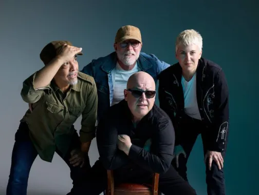 Group portrait of legendary alt-rock band PIXIES posing with casual confidence against a neutral studio backdrop.